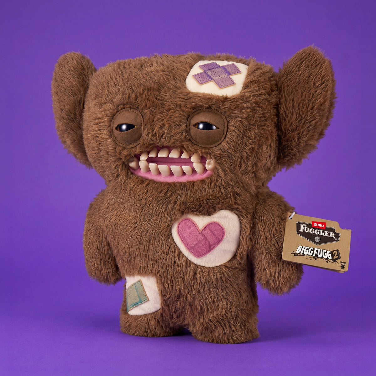 Fuggler Bigg Fugg Grumpy Grumps 18-Inch Plush featuring fuzzy brown fur, human-like teeth, and large heavy-lidded eyes.