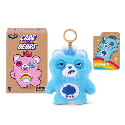 Fuggler Care Bears blind box packaging alongside an assortment of plush bag charms featuring Care Bear designs and human-like teeth.