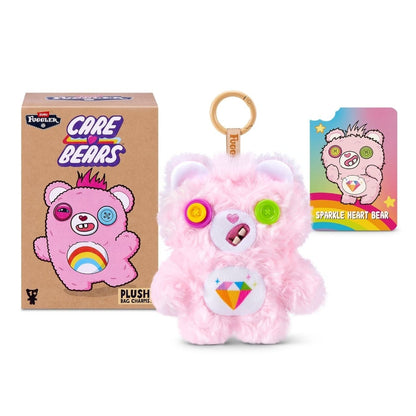 Fuggler Care Bears blind box packaging alongside an assortment of plush bag charms featuring Care Bear designs and human-like teeth.
