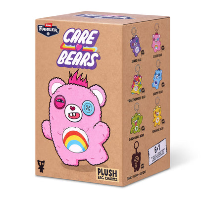 Fuggler Care Bears blind box packaging alongside an assortment of plush bag charms featuring Care Bear designs and human-like teeth.