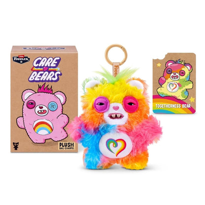 Fuggler Care Bears blind box packaging alongside an assortment of plush bag charms featuring Care Bear designs and human-like teeth.