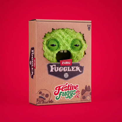 A cardboard product box for the Zuru Fuggler Festive Fugs, featuring a green fuzzy monster face cutout on the front, set against a solid red background.