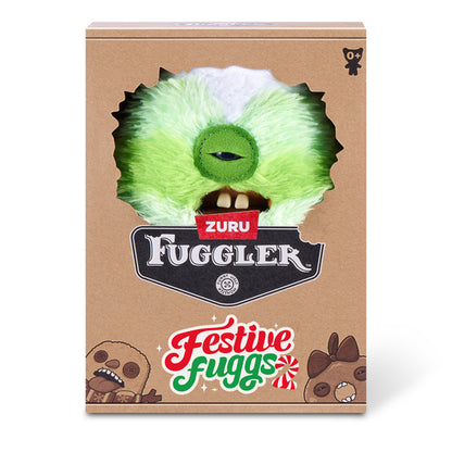 A cardboard product box for Zuru Fuggler 'Festive Fuggs' featuring a die-cut window showing a green furry monster face with a single eye and teeth, on a white background.