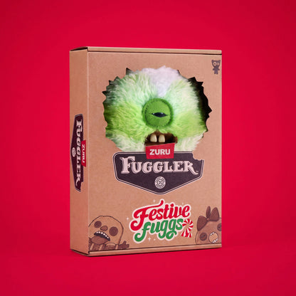 A brown cardboard product box for the Zuru Fuggler, featuring a die-cut window showing a green furry monster head with one eye. The box has 'ZURU FUGGLER' branding and 'Festive Fuggs' text, set against a solid red background.
