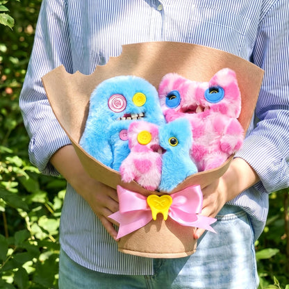 Fuggler Fugg Bouquets Plush Set featuring two 9-inch and one 3.5-inch blue and pink monster plush toys wrapped in craft paper with a pink ribbon.