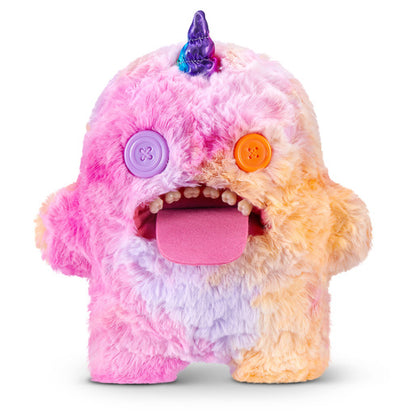 Fuggler Fugglercorns Oogah Boogah plush toy with pastel tie-dye fur in pink, purple, and orange, a metallic purple unicorn horn, mismatched button eyes, a large pink tongue sticking out, and human-like teeth.