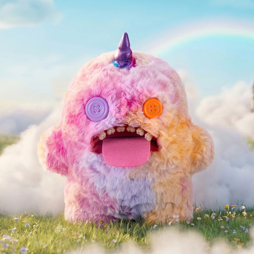 Fuggler Fugglercorns Oogah Boogah plush toy with pastel tie-dye fur in pink, purple, and orange, a metallic purple unicorn horn, mismatched button eyes, a large pink tongue sticking out, and human-like teeth.