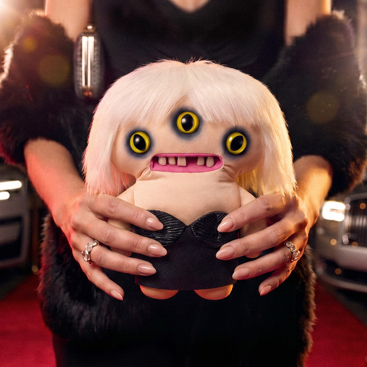 Fuggler Fuggstars Series 2 Lady Fugg plush wearing a black bustier with a platinum blonde bob haircut, three eyes, and human-like teeth.