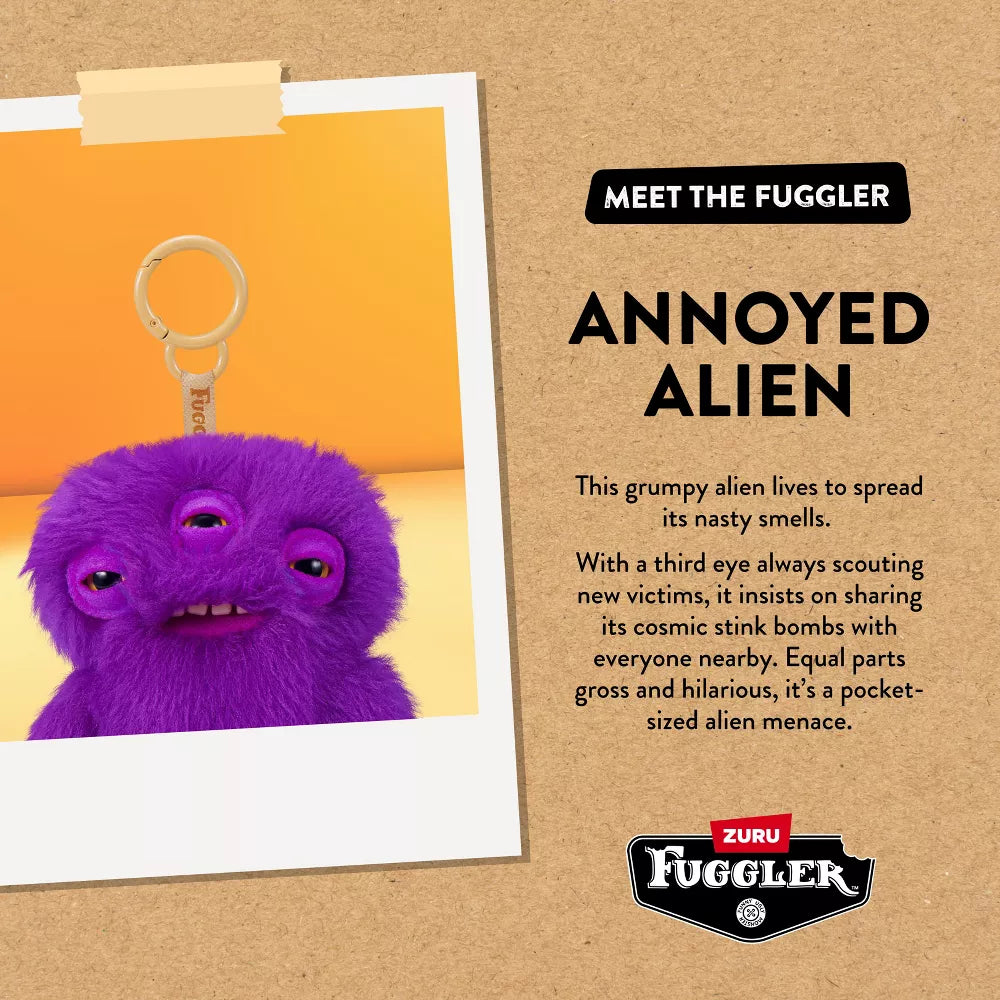 Purple alien keychain with text on a brown background