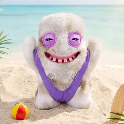 Fuggler Nipple Fuggs Shameless Goof plush toy with fluffy light tan fur, wearing a purple swimsuit, featuring sleepy purple eyes and a wide smile with human-like teeth with a purple outfit on a beach with a ball and sandcastle.
