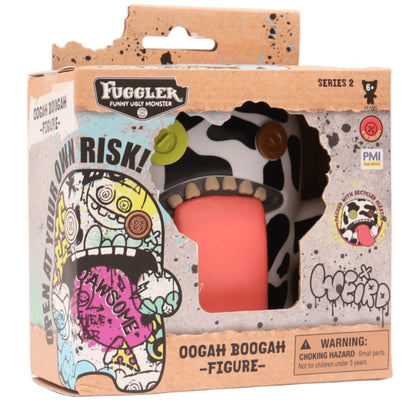 Fuggler Oogah Boogah 4.5-inch figure featuring a black and white cow print pattern, mismatched button eyes, and a giant tongue sticking out.