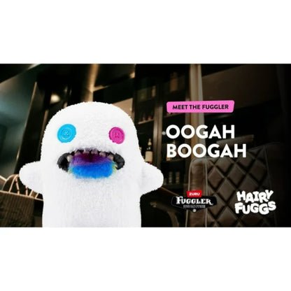 Oogah Boogah Fuggler plush by ZURU with hairy tongue and teeth with colorful eyes and mouth, labeled 'Oogah Boogah', in a blurred indoor setting.