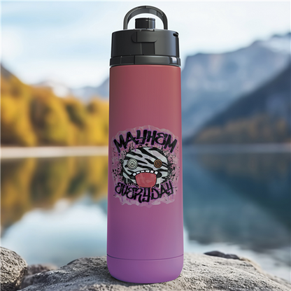 Purple water bottle with a zebra design and text on a rock by a lake with mountains in the background