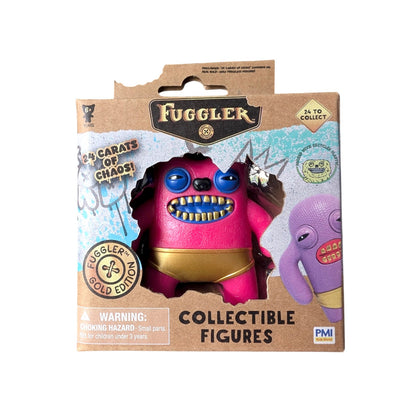 Fuggler Series 3 Gold Edition Greedy Grinner vinyl figure featuring a pink body, blue eyes, gold teeth, and gold underwear in a 24 Carats of Chaos window box.