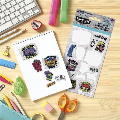 Sticker sheet with colorful designs on a notebook next to stationery items on a wooden surface