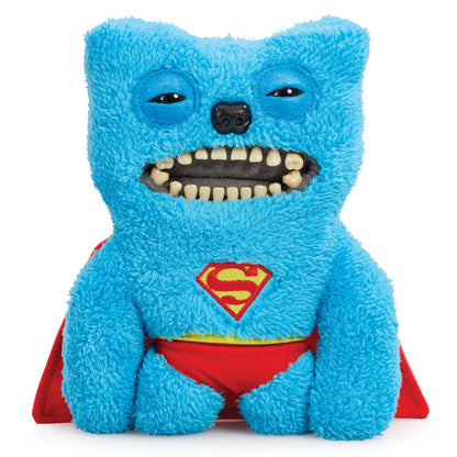 A product shot of the Fuggler x DC Superman 9-Inch plush toy, featuring blue fuzzy fur, a red cape, and the Superman emblem, with a wide grin full of human-like teeth.