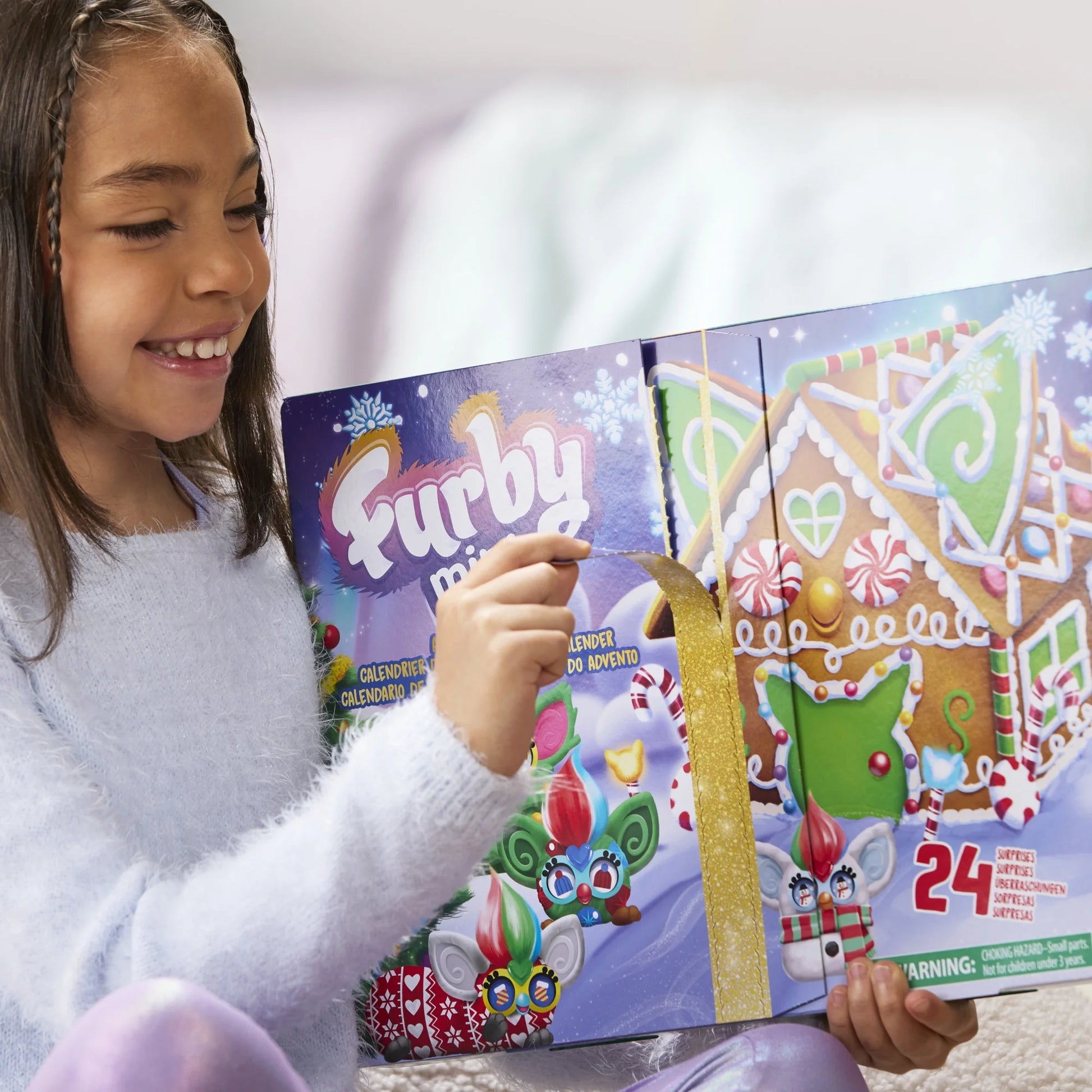 A child opening a holiday Furby Advent calendar.