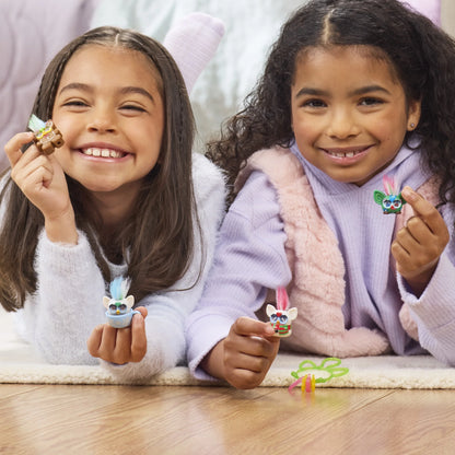 Two children holding miniature Furby figurines.