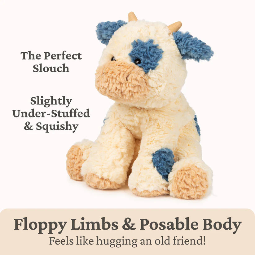 Stuffed animal cow with blue patches on a white background