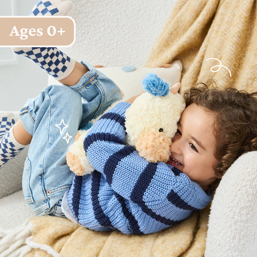 Child holding a plush toy on a couch with 'Ages 0+' text above
