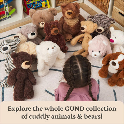 Group of Gund stuffed animals including teddy bears and a child sitting among them on a rug.