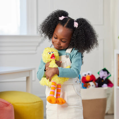 Child holding a yellow plush toy in a room with other toys in the background