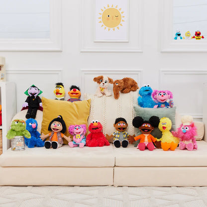 Colorful plush toys arranged on a couch with a decorative wall in the background