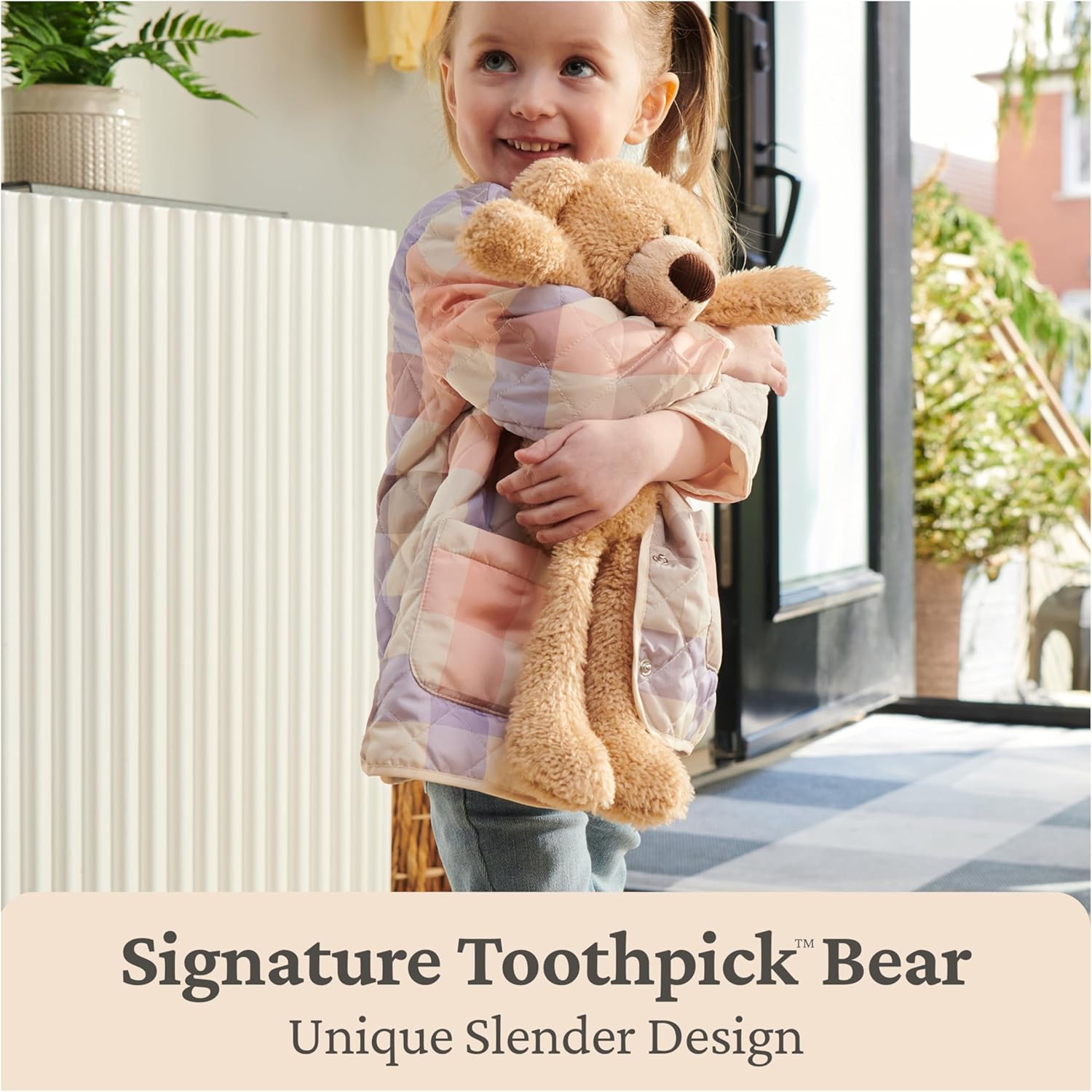 Child holding a teddy bear wrapped in a blanket with text about a 'Signature Toothpick Bear' design.
