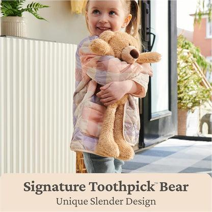 Child holding a teddy bear wrapped in a blanket with text about a 'Signature Toothpick Bear' design.