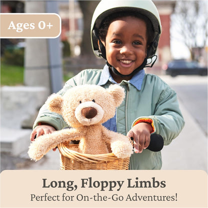 Child with helmet holding teddy bear in a basket, outdoor setting