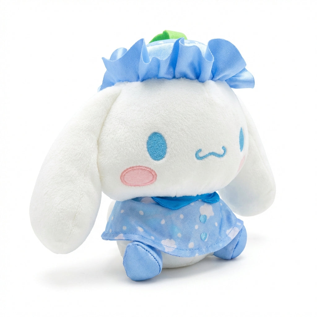 Hello Kitty and Friends plush featuring Cinnamoroll wearing a blue ruffled hat with a green leaf and a matching sky-blue cape with cloud patterns and heart buttons.