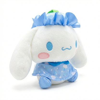 Hello Kitty and Friends plush featuring Cinnamoroll wearing a blue ruffled hat with a green leaf and a matching sky-blue cape with cloud patterns and heart buttons.