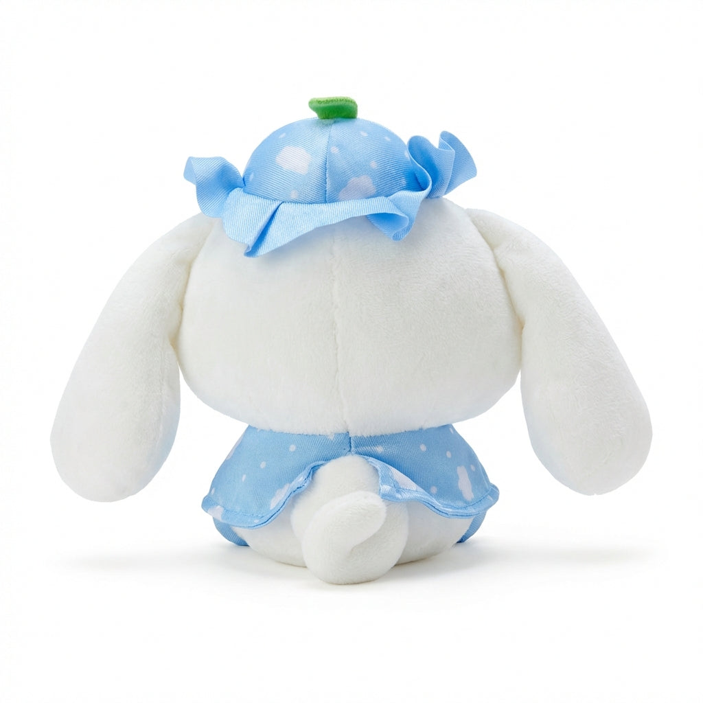 Hello Kitty and Friends plush featuring Cinnamoroll wearing a blue ruffled hat with a green leaf and a matching sky-blue cape with cloud patterns and heart buttons.