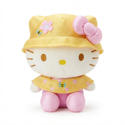 Hello Kitty and Friends plush featuring Hello Kitty wearing a yellow bucket hat and cape with pink flowers and bee details, along with her signature pink bow.