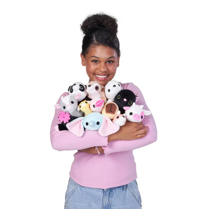 Person holding a collection of baby-size weighted plush toy by ZURU 