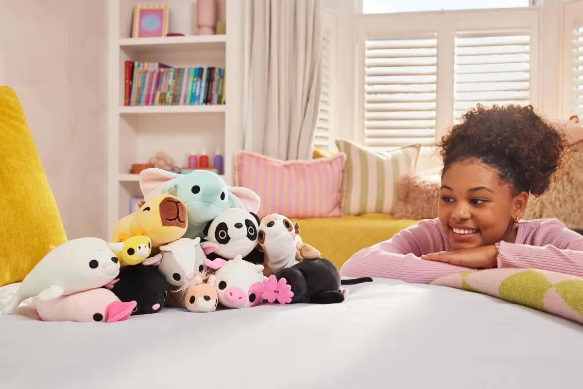 Girl with plush toys on a bed in a cozy room