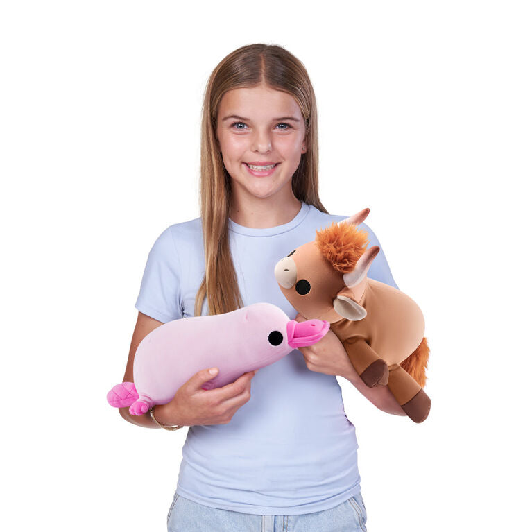 Young girl holding a Holly the Highland Cow small weighted plush toy by ZURU featuring shaggy orange hair and soft tan fur.