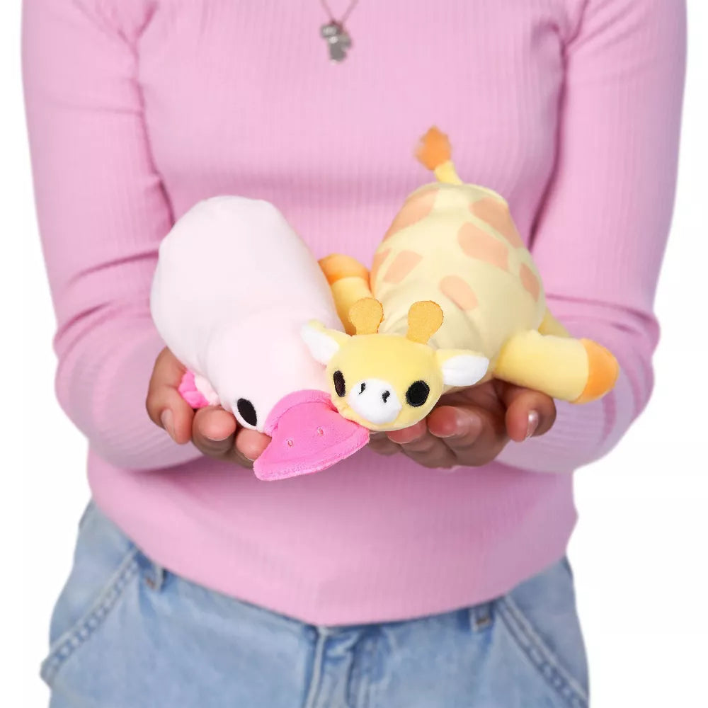 Person holding Perry the Platypus baby-size weighted plush toy by ZURU featuring a soft pink body and bright fuchsia bill.