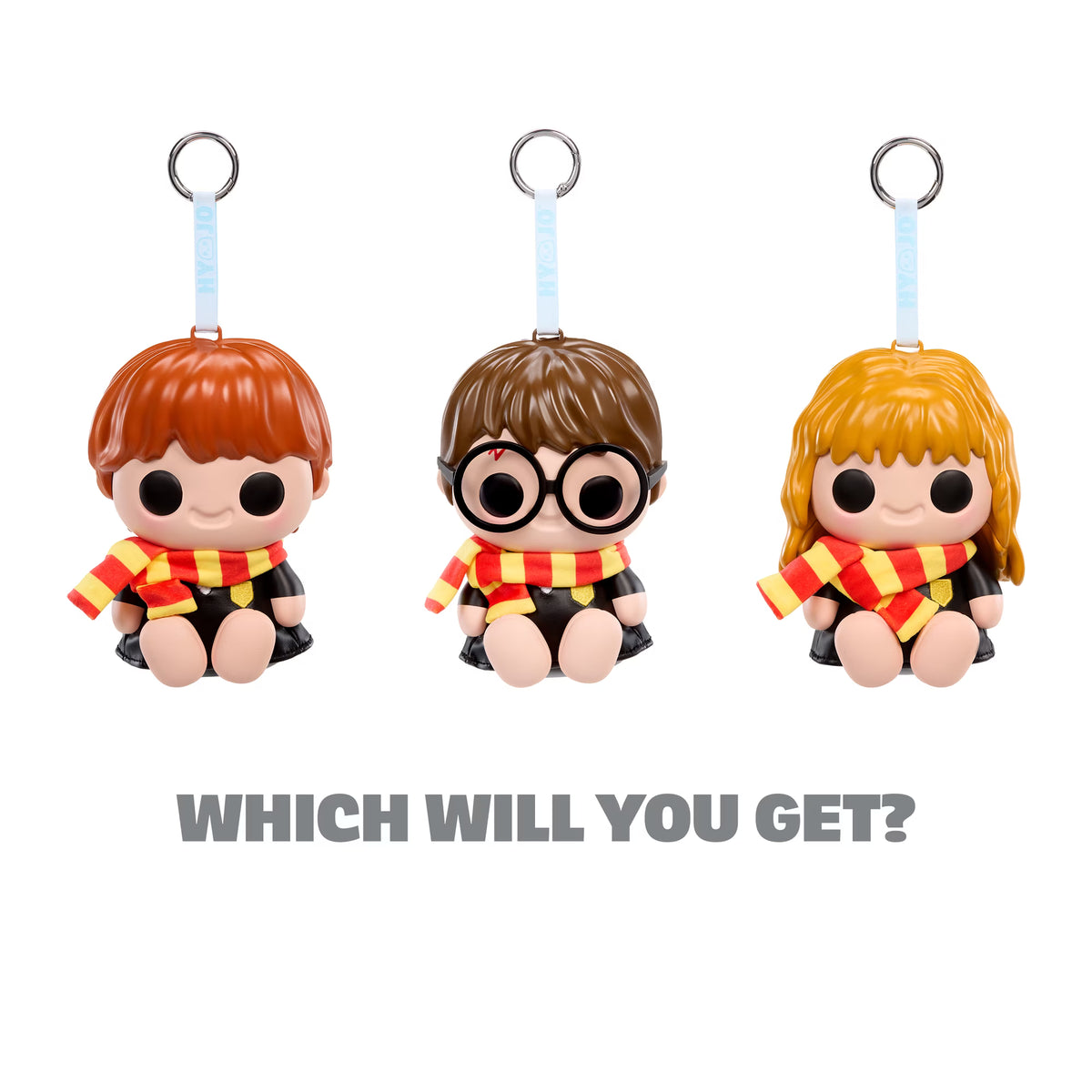 Three small character keychain figures with metal key rings are shown on a white background, with the text 'WHICH WILL YOU GET?' below them. The figures resemble Harry Potter characters and each wears a red and yellow striped scarf.