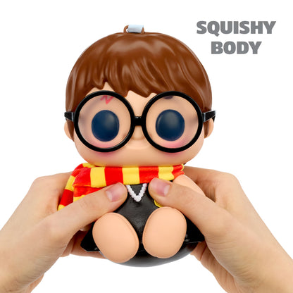 A squishy toy figure with a brown-haired character design, round black glasses, and a red and yellow striped scarf, being held by two hands against a white background. The text 'SQUISHY BODY' is visible in the top right corner.