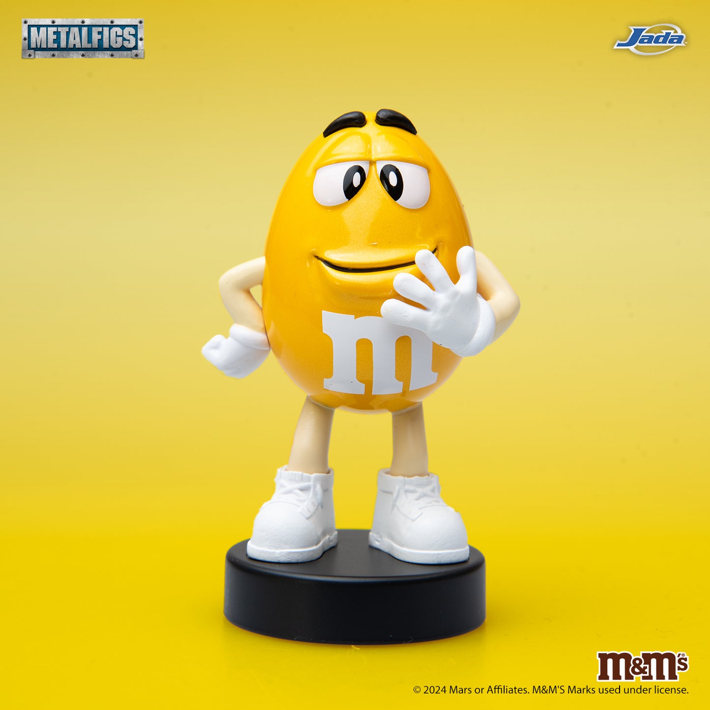 Jada Toys M&M's Yellow Character 2.5-inch Metalfigs die-cast figure mounted on a black display pedestal.