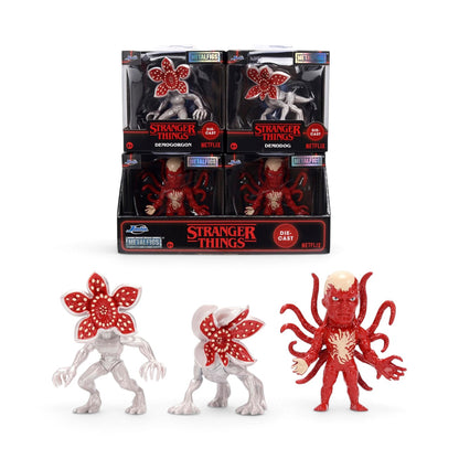 Stranger Things Metalfigs figure display set featuring three red and white Demogorgon figures, with four packaged figures displayed in a black retail counter box on a white background.