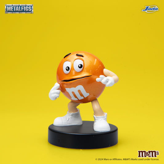 Jada Toys M&M's Orange Character 2.5-inch die-cast metal figure standing with a nervous expression and hands on his face on a black pedestal.