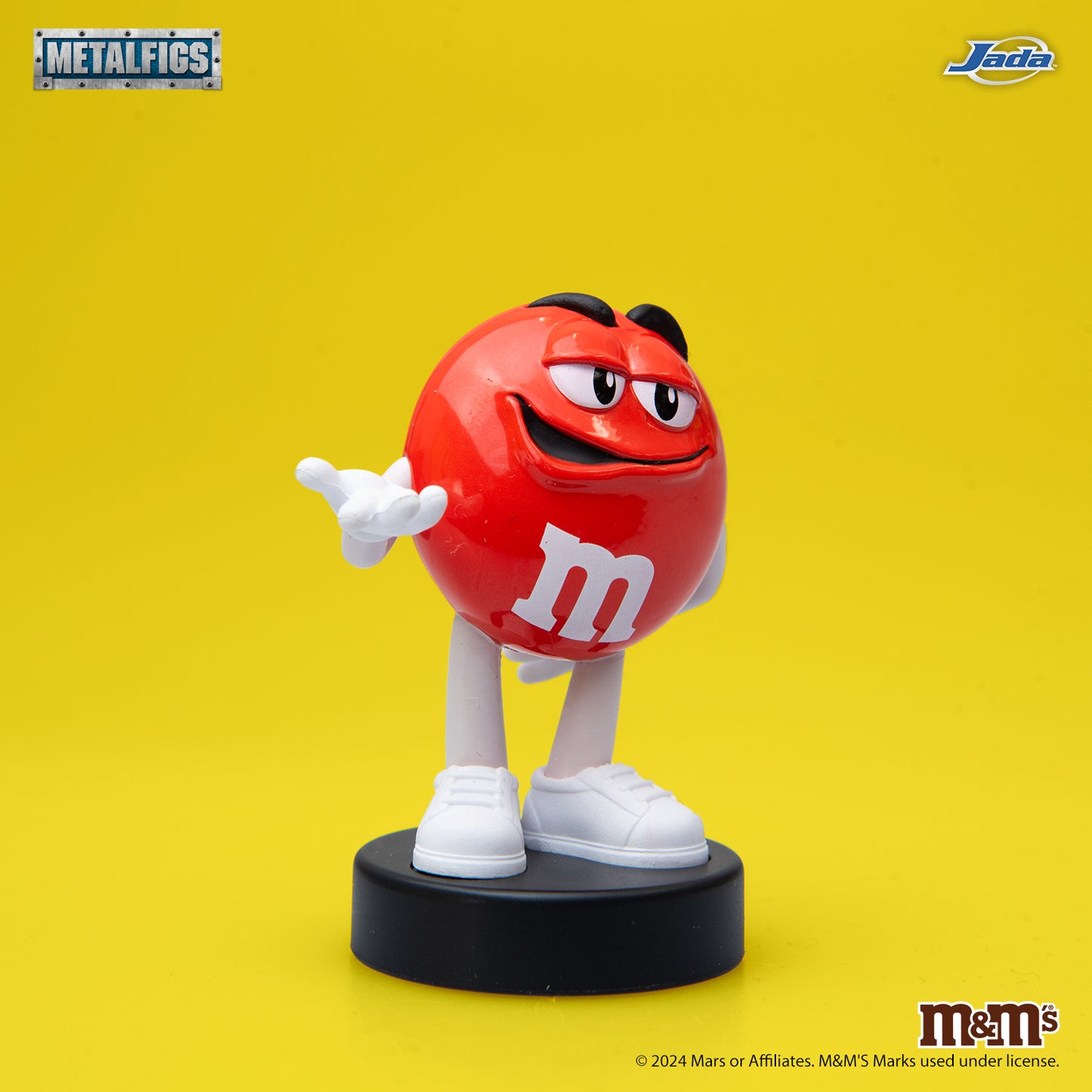 Jada Toys M&M's Red Character 2.5-inch die-cast metal figure standing confidently with hands on hips on a black pedestal.