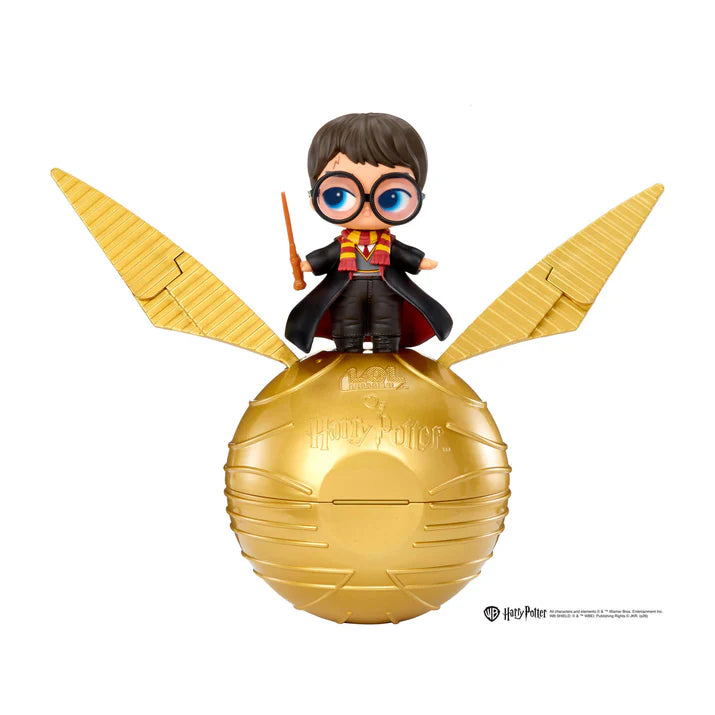 Harry Potter Golden Snitch figure with a small Harry character standing on top of a gold-colored spherical巢 with large golden wings, shown against a plain white background.