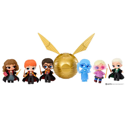 A set of Harry Potter surprise toy figures and a golden snitch, including Hermione, Ron, Harry, Ginny, Luna, Draco, and Dumbledore, arranged in a row with a large gold glittery snitch in the center on a white background.