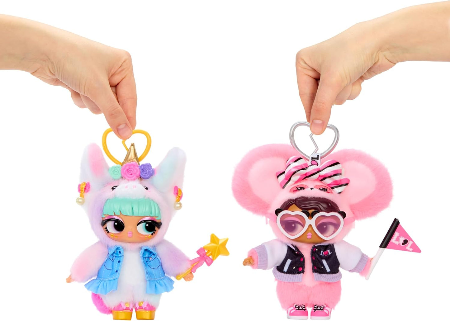 Two plush doll keychains being held up by human hands against a plain white background. The left keychain is pastel pink and white with a unicorn hood, mint green hair, and a blue skirt, holding a yellow star wand.