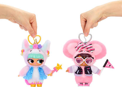 Two plush doll keychains being held up by human hands against a plain white background. The left keychain is pastel pink and white with a unicorn hood, mint green hair, and a blue skirt, holding a yellow star wand.