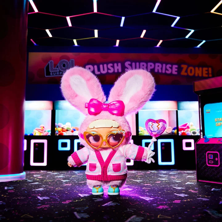 A plush surprise toy character dressed in a pink bunny outfit with a large pink bow, oversized gold-rimmed glasses, and a white-and-pink cardigan stands in a neon-lit arcade room. The background shows claw machines and a sign reading 'Plush Surprise Zone!'.