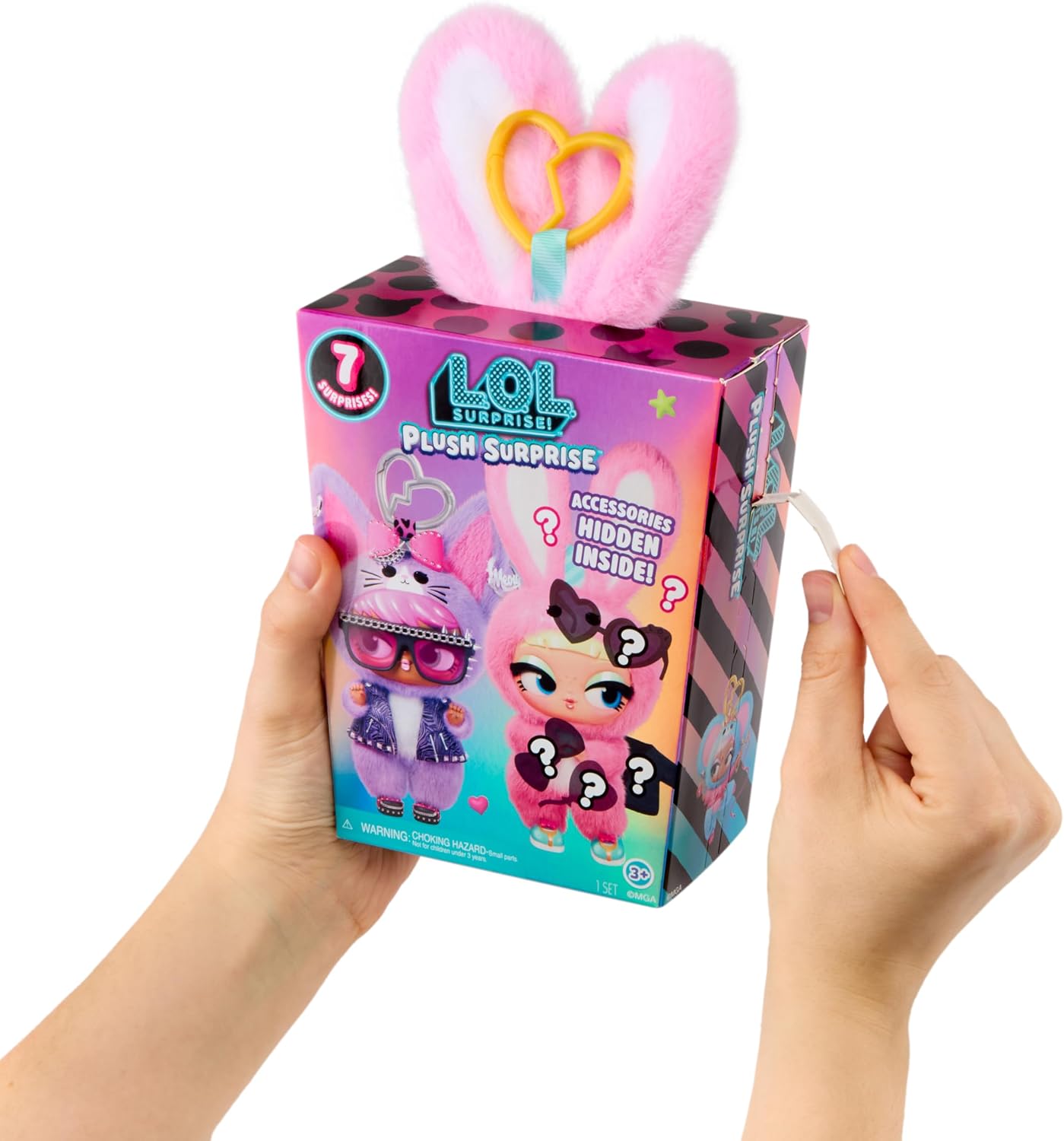 A person's hands holding a LOL Surprise Plush Surprise toy box, with a pink plush bunny head accessory popping out of the top. The box features colorful graphics of a pink bunny doll and text indicating a mystery plush inside.